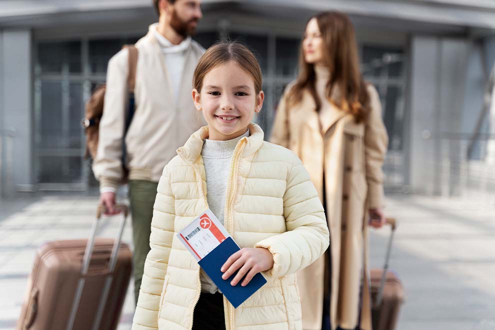 Criança sorridente segurando passaporte em aeroporto