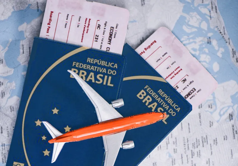 passaporte com passagens encima de um mapa mundo com avião de brinquedo em cima dos passaporte 