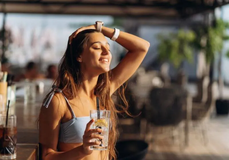 mulher feliz, com um copo de bebida alcoólica na mão 