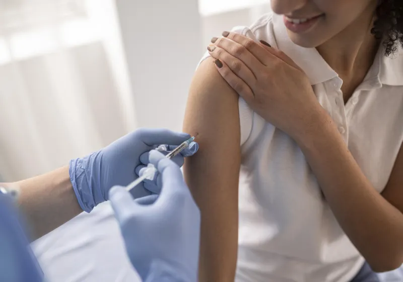 mulher em um posto de saúde tomando vacina 