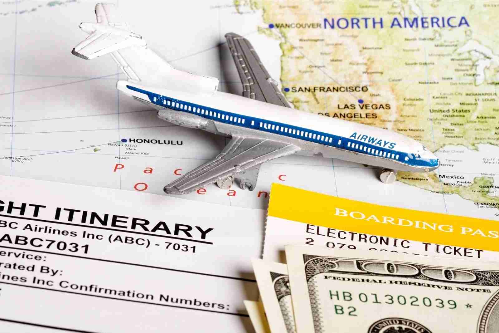mapa dinheiro e uma miniatura de avião encima da mesa