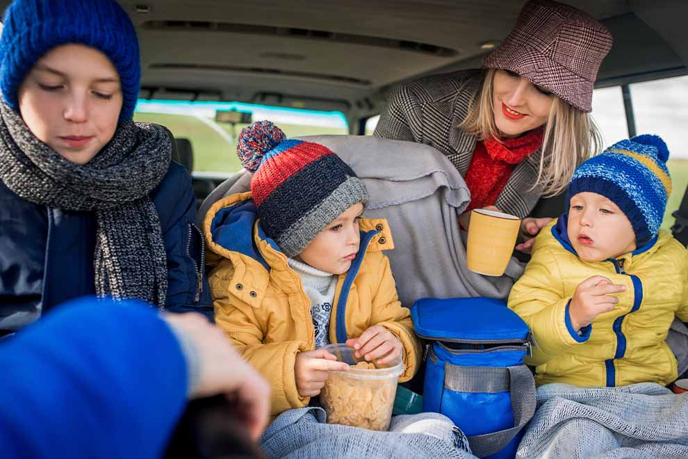 Crianças e mulher conversando dentro de carro
