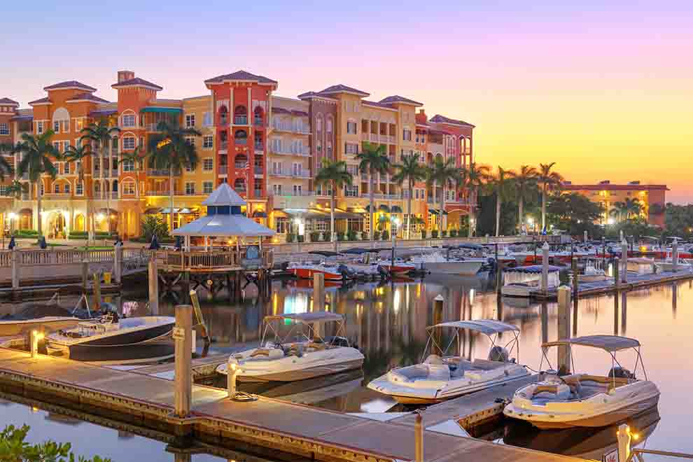Marina com barcos e edifícios ao pôr do sol