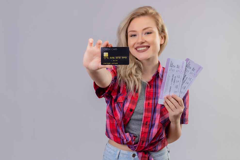 Mulher segurando cartão de crédito e ingressos