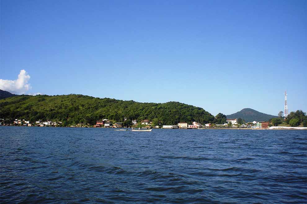 Vista do mar com montanhas e casas à beira da água