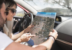 Casal olhando um mapa dentro do carro
