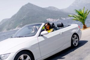 Carro conversível em estrada à beira-mar