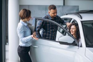 Clientes interagindo com vendedor de carros
