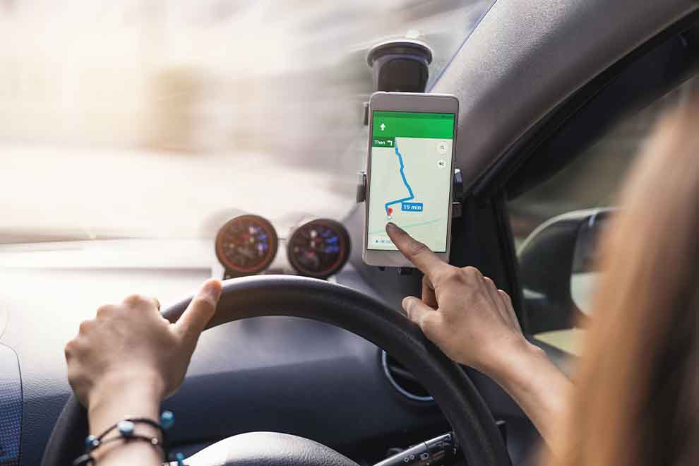 Pessoa dirigindo com um GPS no painel do carro.