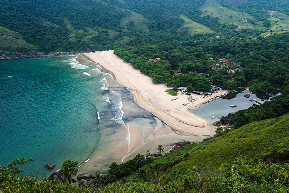 Vista aérea da praia rodeada por vegetação exuberante