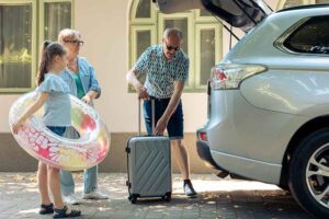 Família preparando malas para viagem de carro