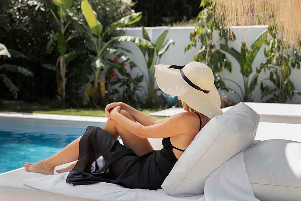 Mulher relaxando à beira da piscina em um dia ensolarado