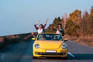Amigos se divertindo em carro amarelo na estrada