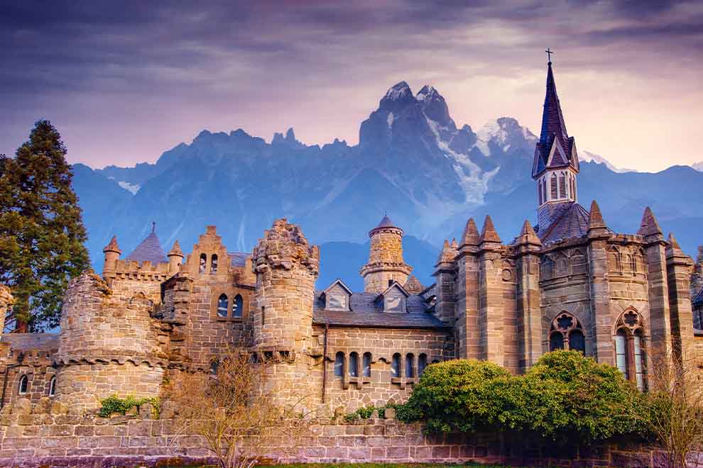 Castelo histórico com montanhas ao fundo