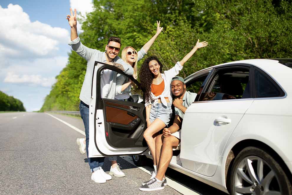 Grupo de amigos se divertindo em um carro na estrada