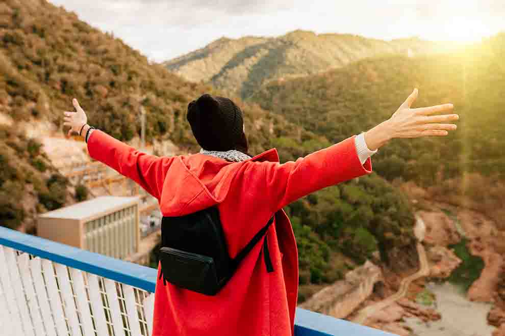 Pessoa de vermelho em montanha ao pôr do sol