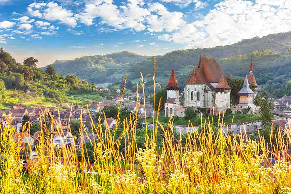 Castelo em meio a montanhas e céu azul claro