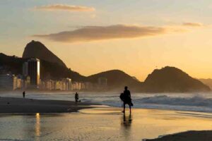 Viajar no volante pelo Rio de Janeiro é a forma mais autêntica e prazerosa de conhecer toda a diversidade do litoral fluminense. Ao dirigir pelas estradas, é possível escolher o ritmo, visitar várias praias no mesmo dia e descobrir joias escondidas fora das rotas turísticas tradicionais. Seja em um bate-volta ou em um roteiro mais completo, a liberdade de parar onde quiser — seja para um mergulho, uma boa refeição ou uma foto com vista para o mar! A Happy Tours torna essa experiência ainda mais fácil, com aluguel de veículos no RJ com reservas online e sem cartão de crédito, para quem quer desbravar o Rio com conforto e autonomia. Agora, sim, vamos para as dicas de 5 melhores praias do Rio de Janeiro para visitar de carro! 1. Praia de Grumari Com natureza preservada, mar azul e areias claras, Grumari é um verdadeiro refúgio para quem busca paz e contato direto com o meio ambiente. O acesso é simples e o estacionamento fica próximo à areia, o que torna o passeio ainda mais agradável. Além disso, o local é ideal para quem prefere um dia longe das multidões, cercado apenas por sons da natureza e um visual impressionante. 2. Prainha Cercada por morros cobertos de Mata Atlântica, a Prainha é um dos recantos mais encantadores do litoral carioca. O mar, com ondas fortes, atrai surfistas o ano todo, enquanto os mirantes próximos oferecem vistas dignas de cartão-postal. É importante chegar cedo, já que o estacionamento é limitado — e cada minuto ali vale a pena. 3. Praia do Recreio dos Bandeirantes Com uma faixa de areia ampla e bem cuidada, o Recreio é o ponto ideal para famílias e esportistas. A orla conta com quiosques animados, ciclovia, calçadão e ótima infraestrutura. Assim, é possível aproveitar o dia inteiro com conforto, alternando entre um mergulho, um passeio de bike ou um petisco à beira-mar. 4. Praia do Pepê (Barra) Moderna e descontraída, a Praia do Pepê é um clássico da Zona Oeste. Os quiosques sempre cheios e a gastronomia variada criam um clima vibrante, especialmente ao pôr do sol, quando o céu ganha tons alaranjados. Aos fins de semana, o local se transforma em ponto de encontro de quem quer curtir boa música, gente bonita e energia leve. Idade mínima para alugar carro: o guia da Happy Tours 5. Praia de Ipanema Famosa em todo o mundo, Ipanema conquista com sua vista para o Morro Dois Irmãos e com o pôr do sol mais icônico do Rio. Apesar de o estacionamento ser limitado, o ambiente cultural e animado compensa qualquer esforço. Entre banhos de mar, rodas de samba e lojinhas charmosas, é impossível não se deixar contagiar pelo espírito carioca. 6. Praia do Leblon Sofisticada e acolhedora, a Praia do Leblon é uma extensão natural de Ipanema, mas com clima mais tranquilo. Além do mar convidativo, o bairro oferece ótimos restaurantes, padarias tradicionais e cafés à beira-mar. É o lugar certo para relaxar, caminhar ao entardecer e apreciar o movimento sem pressa. 7. Praia Vermelha Pequena, charmosa e com vista deslumbrante para o Pão de Açúcar, a Praia Vermelha combina beleza natural e atmosfera serena. O acesso fácil e o estacionamento próximo tornam o passeio ainda mais cômodo. Para completar o dia, vale caminhar pela pista Cláudio Coutinho, que contorna o morro e revela ângulos incríveis da paisagem. 8. Praia do Leme Como continuação de Copacabana, o Leme oferece uma versão mais calma e familiar do famoso bairro. Com mar tranquilo e quiosques acolhedores, é perfeito para quem quer relaxar sem abdicar da estrutura urbana. O pôr do sol visto do mirante do Leme é um espetáculo à parte. Aplicativos de viagem: melhores apps para seu planejamento 9. Praia da Barra da Tijuca Com mais de 18 km de extensão, a Barra é sinônimo de liberdade e variedade. A praia combina trechos movimentados, com bares e esportes, e áreas mais reservadas, ideais para quem busca sossego depois da balada. A boa infraestrutura e o fácil acesso garantem conforto para passar o dia todo à beira-mar. 10. Praia de Joatinga Escondida entre as pedras e acessível por uma curta trilha, Joatinga é um tesouro natural do Rio. O mar verde-esmeralda e o visual panorâmico criam um cenário digno de filme. Apesar do estacionamento ser limitado, a sensação de exclusividade e o ambiente tranquilo fazem o esforço valer a pena. 11. Praia de São Conrado Entre o mar e a montanha, São Conrado impressiona pelo contraste das paisagens. Além de ser famosa pelos voos de asa-delta, a praia oferece um visual espetacular do Morro Dois Irmãos. É o destino perfeito para quem gosta de aventura, fotografia e boas caminhadas à beira-mar. 12. Praia de Copacabana O calçadão mais famoso do Brasil dispensa apresentações. Com bares, quiosques e hotéis históricos, Copacabana respira história e alegria. A combinação de mar, cultura e vida urbana cria uma atmosfera única, que encanta turistas e moradores em qualquer época do ano. Como planejar uma viagem financeiramente? Veja 7 dicas! 13. Praia da Reserva Localizada entre a Barra e o Recreio, a Praia da Reserva é o refúgio ideal para quem busca tranquilidade. O mar limpo, a areia fina e a natureza intocada formam um cenário relaxante. Além disso, o ambiente preservado e o clima sossegado fazem dela uma das mais bonitas da cidade. 14. Praia de Itacoatiara (Niterói) Com mar forte, areia dourada e montanhas imponentes, Itacoatiara é um espetáculo visual. O local é muito procurado por surfistas e trilheiros, que sobem o Costão para apreciar uma das vistas mais lindas da região. Em dias de sol, o contraste entre o azul do mar e o verde das pedras é de tirar o fôlego. 15. Praia de Camboinhas (Niterói) De águas calmas e clima acolhedor, Camboinhas é ideal para famílias com crianças. Os restaurantes à beira-mar oferecem boa comida e vista encantadora, enquanto o pôr do sol reflete tons dourados sobre o mar. É uma ótima pedida para um passeio tranquilo e cheio de charme. Cidades desconhecidas do Brasil: 7 lugares para conhecer 16. Praia de Piratininga (Niterói) Com extensa faixa de areia e ambiente descontraído, Piratininga é perfeita para um dia de lazer. Dá para caminhar, praticar esportes ou apenas relaxar observando o horizonte voltado para o Rio. O mar é convidativo, e o visual panorâmico torna cada momento especial. 17. Praia do Forte (Cabo Frio) Com águas cristalinas e areia branca, o Forte é o coração turístico de Cabo Frio. A excelente infraestrutura e a vida noturna animada fazem da praia um ponto completo. É ideal tanto para famílias quanto para quem quer unir descanso, diversão e boa gastronomia. 18. Praia das Conchas (Cabo Frio) Pequena, charmosa e cercada por morros, a Praia das Conchas é perfeita para famílias. O mar calmo convida a longos banhos e momentos de descanso. Além disso, a vista do alto das trilhas revela ângulos lindos da costa, tornando o passeio ainda mais memorável. 19. Praia do Peró (Cabo Frio) Mais reservada e tranquila, a Praia do Peró encanta por suas dunas e mar de ondas suaves. É uma ótima alternativa para quem quer fugir do agito, aproveitar o visual natural e relaxar ao som do mar. 5 lugares baratos para viajar de carro na América Latina 20. Praia do Farol (Arraial do Cabo) Considerada uma das mais belas do Brasil, a Praia do Farol tem acesso controlado por barco — o embarque é feito facilmente de carro até o cais. O mar cristalino, as areias claras e a vegetação preservada formam um dos cenários mais paradisíacos da costa fluminense. 21. Praia do Forno (Arraial do Cabo) Com trilha leve e vista impressionante, a Praia do Forno encanta à primeira vista. Suas águas transparentes convidam a mergulhos relaxantes, enquanto a atmosfera tranquila torna o passeio inesquecível. 22. Praia Grande (Arraial do Cabo) Ampla, com mar aberto e um pôr do sol de tirar o fôlego, a Praia Grande é uma das mais visitadas da Região dos Lagos. Além da beleza natural, conta com ótima estrutura e quiosques que garantem conforto durante todo o dia. 23. Praia dos Anjos (Arraial do Cabo) Com clima vibrante e orla movimentada, a Praia dos Anjos é o ponto de partida para passeios de barco e mergulhos. Além disso, os restaurantes à beira-mar oferecem boa comida e música ao vivo, criando uma atmosfera acolhedora e animada. 24. Praia de Geribá (Búzios) Badalada e cheia de energia, Geribá é a preferida dos surfistas e jovens viajantes. Durante o verão, o clima é de festa; fora da alta temporada, o ambiente fica mais sossegado e convidativo. As águas claras e o visual moderno garantem ótimos registros e boas lembranças. 3 cuidados com o carro alugado quando pegar e entregar! 25. Praia da Ferradura (Búzios) Com formato de ferradura e mar calmo, essa praia é ideal para famílias e casais. O cenário é encantador, e os restaurantes à beira-mar oferecem boa comida e atendimento acolhedor. Entre um mergulho e outro, vale relaxar na areia e curtir a brisa leve que sopra do mar. Dicas para aproveitar o roteiro litoral carioca de carro Viajar pelas praias do Rio de Janeiro de carro é uma experiência inesquecível — e com algumas dicas simples, o passeio fica ainda mais tranquilo e prazeroso. Confira nossas dicas! Planeje as paradas para evitar horários de trânsito intenso; Leve água, protetor solar e lanches, pois algumas praias têm pouco comércio; Estacione sempre em locais seguros e permitidos; Prefira carros com ar-condicionado e GPS; Reserve hospedagens próximas à praia para otimizar o tempo; Use aplicativos de navegação para descobrir rotas alternativas; Inclua praias menos conhecidas no roteiro para experiências autênticas. Viva a liberdade de viajar com a Happy Tours Desbravar as melhores praias do Rio de Janeiro de carro é uma experiência inesquecível. Com a Happy Tours EUA, você monta um roteiro personalizado, ajusta o ritmo da viagem e transforma cada parada em uma lembrança a mais. Viajar sobre quatro rodas é decidir o próximo destino no momento, transformar desvios em descobertas e aproveitar o litoral carioca com conforto e segurança. Quer saber mais? Você encontra mais informações em nosso post sobre aluguel de carro no Rio: guia completo e dicas essenciais!
