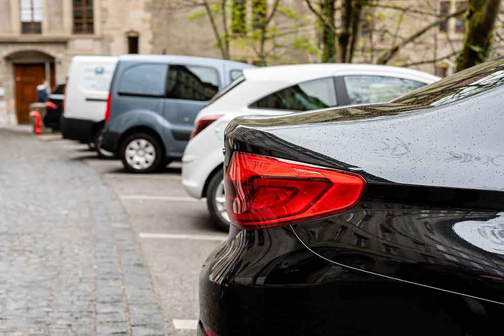 Carros estacionados na rua com chuva