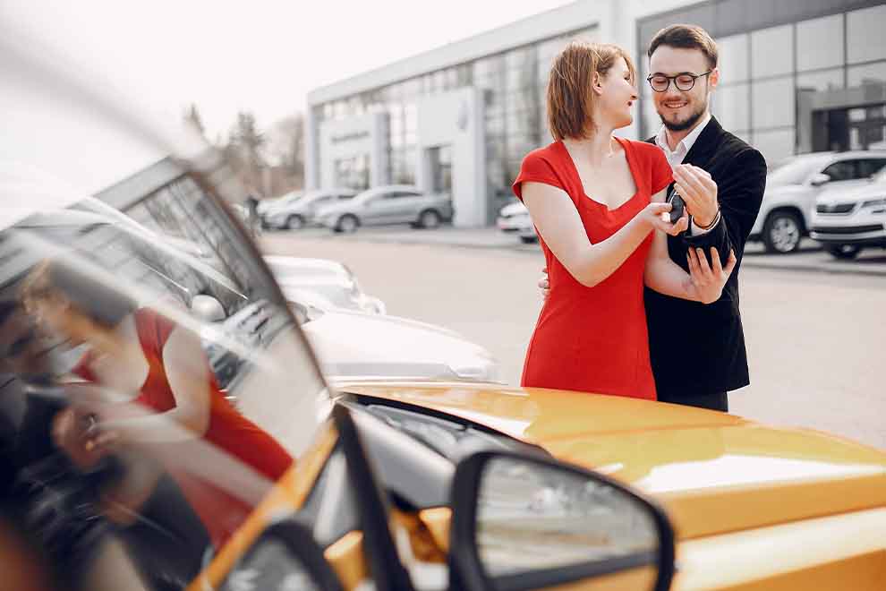 Casal jovem em um carro amarelo no estacionamento