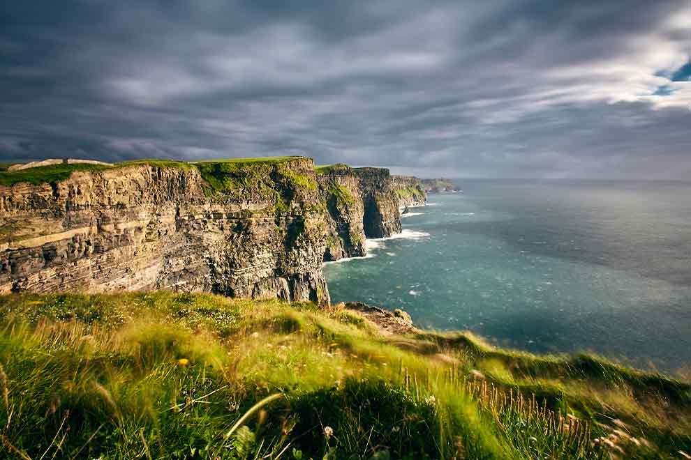 Vista das falésias e mar sob céu nublado